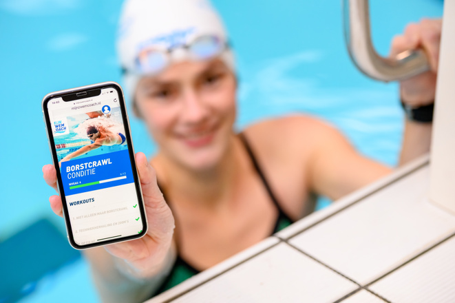 Zwemster toont online schema op haar telefoon