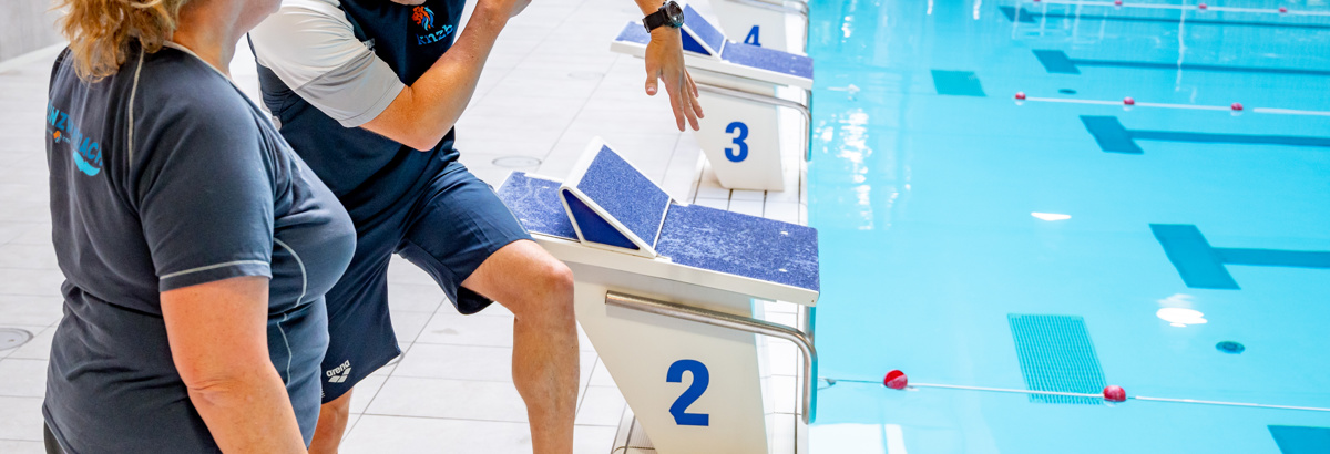 Twee trainers overleggen de juiste houding met elkaar
