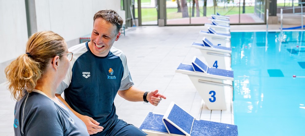 Twee trainers die met elkaar overleggen